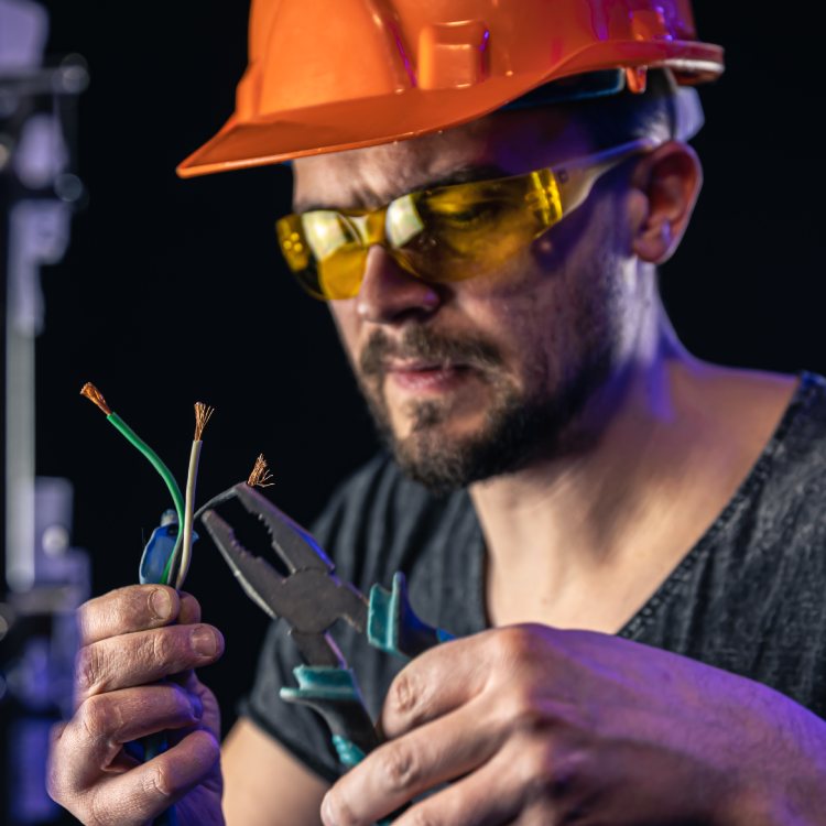 male-electrician-works-switchboard-with-electrical-connecting-cable